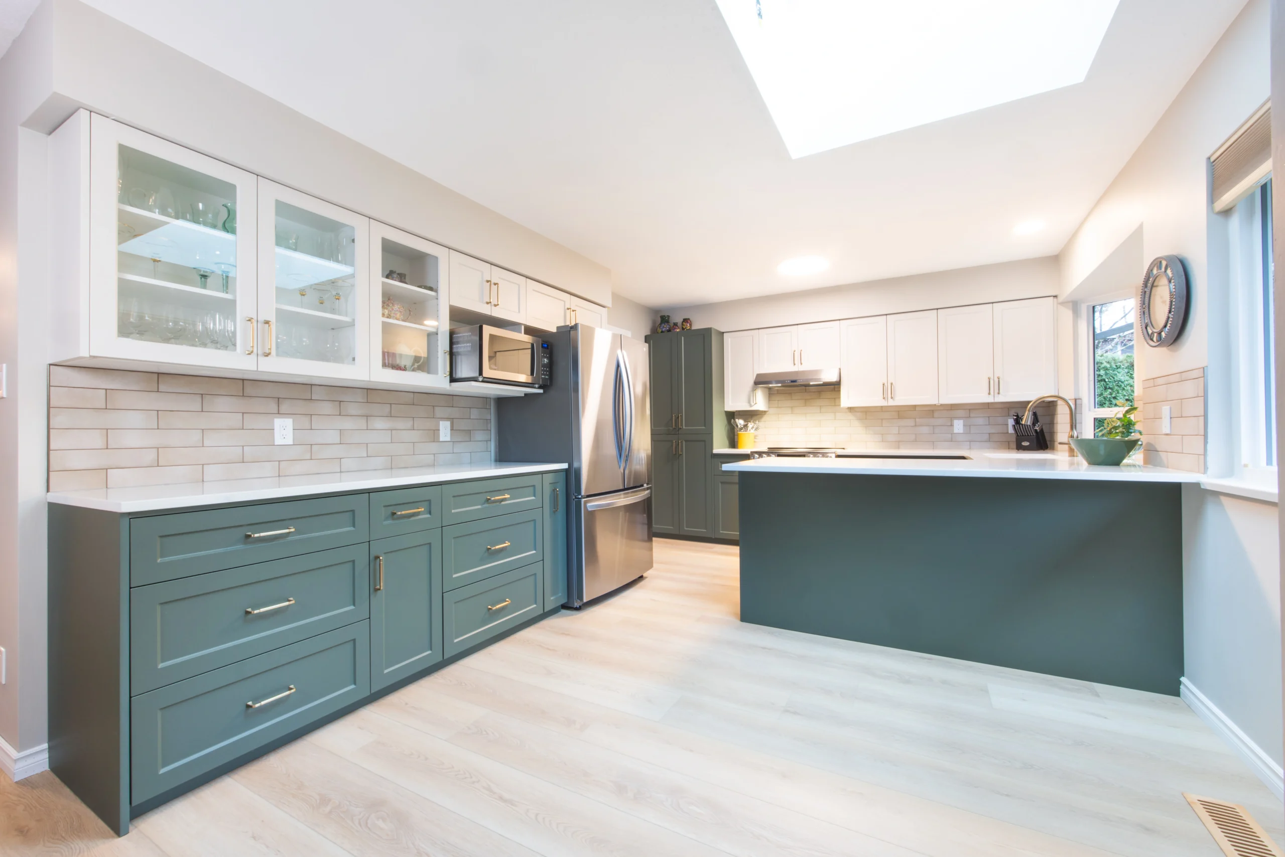 Bright Calgary kitchen remodeling project with white cabinets, large island seating, quartz countertops, and open-concept layout