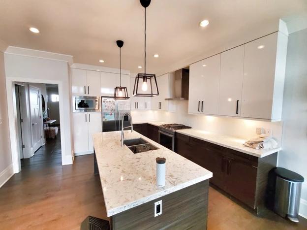 Full kitchen renovation in Vancouver with two-tone cabinets, granite island countertop, stainless steel appliances and pendant lighting by 180 Kitchens